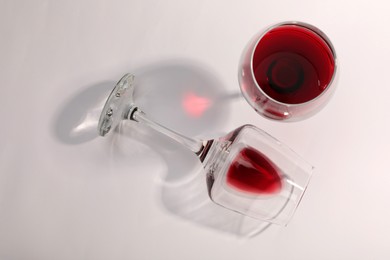 Photo of Tasty red wine in glasses isolated on white, top view