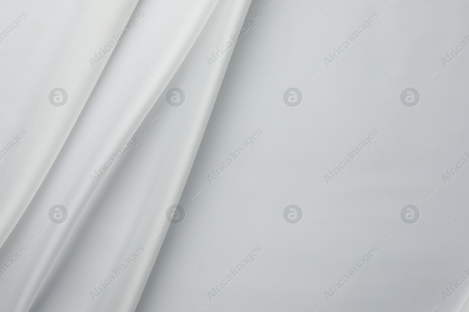 Photo of Texture of crumpled white silk fabric as background, top view. Space for text