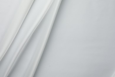 Photo of Texture of crumpled white silk fabric as background, top view. Space for text