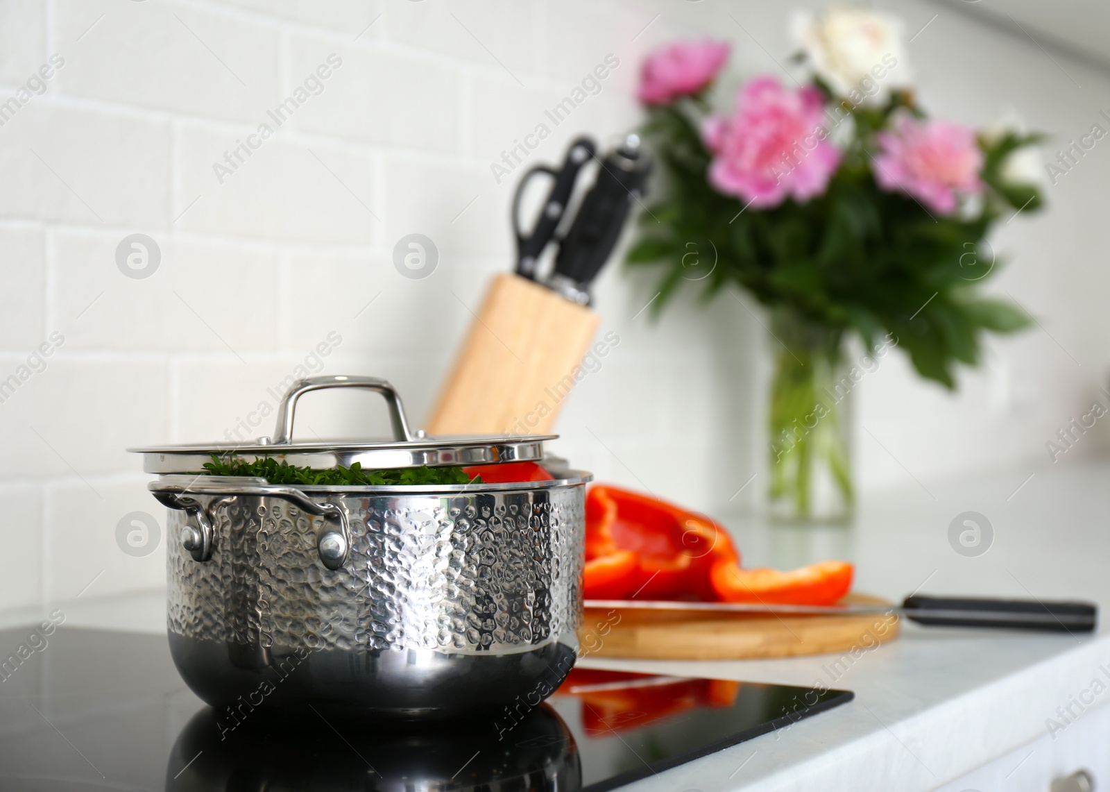 Photo of Saucepot with products on induction stove in kitchen