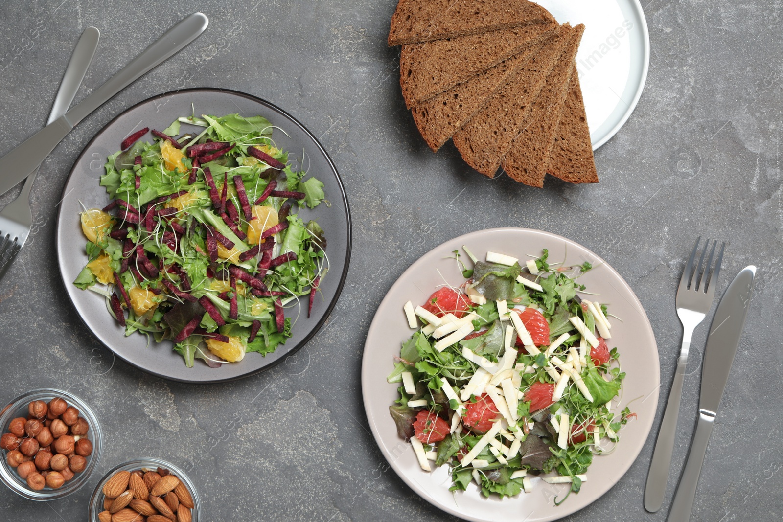 Photo of Delicious carrot salads served on grey table, flat lay