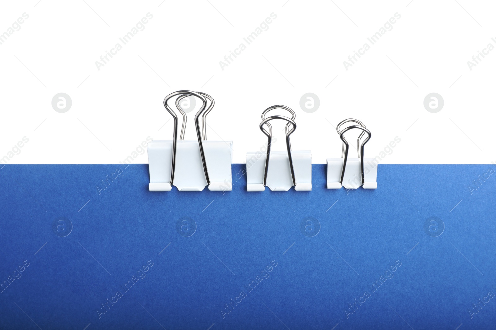 Photo of Blue paper with different binder clips isolated on white