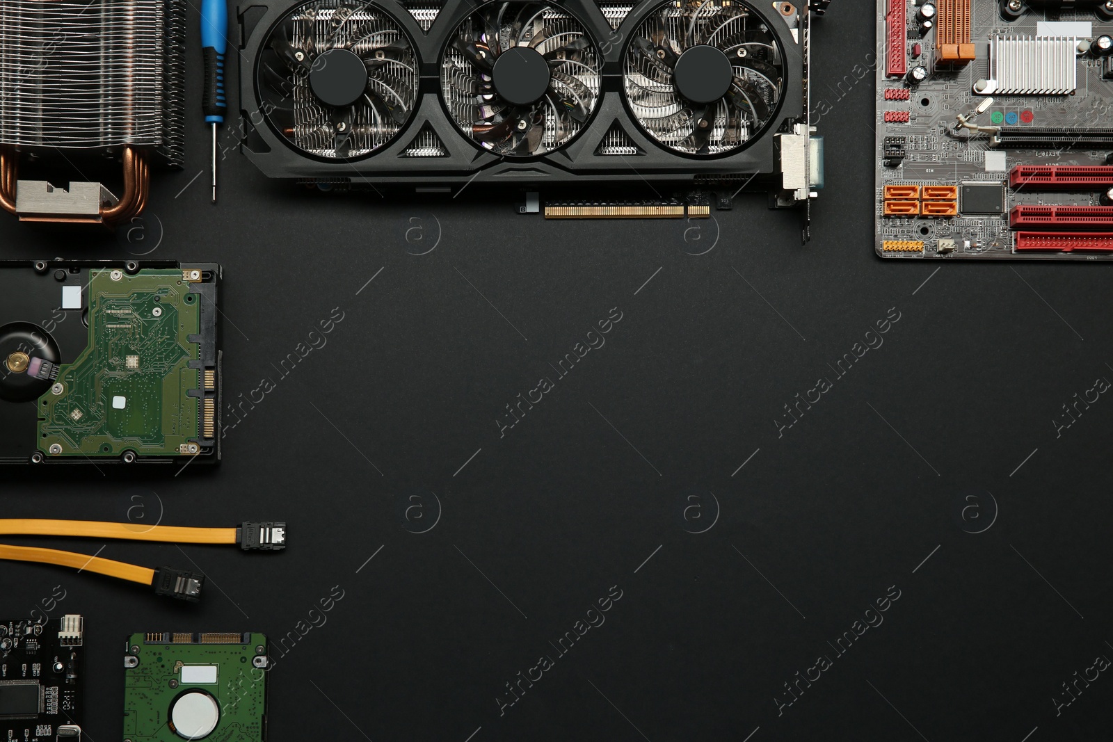 Photo of Graphics card and other computer hardware on black background, flat lay. Space for text