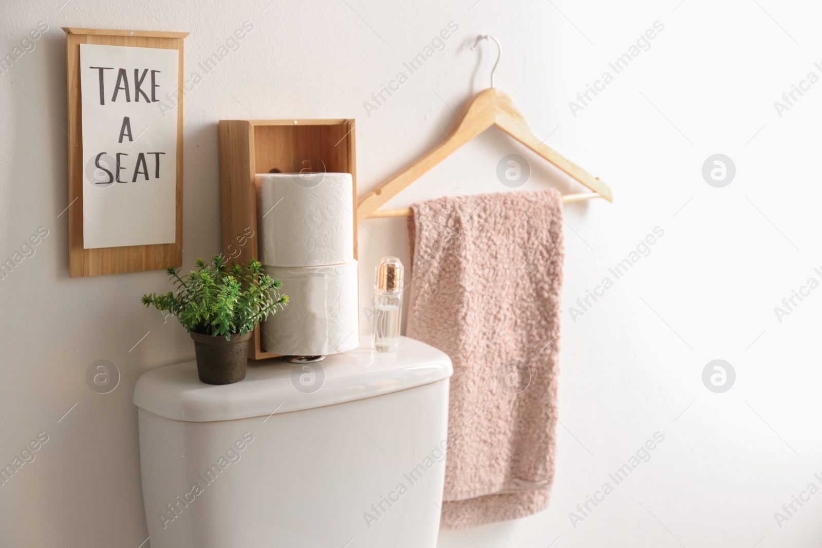 Photo of Decor elements, necessities and toilet bowl near white wall. Bathroom interior