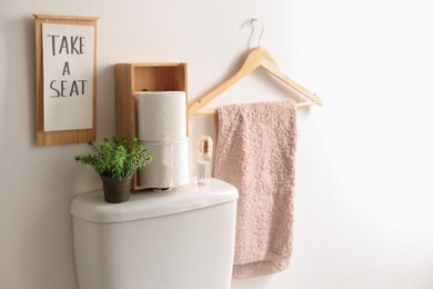 Photo of Decor elements, necessities and toilet bowl near white wall. Bathroom interior