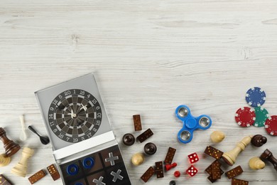 Photo of Elements of different board games on white wooden table, flat lay. Space for text