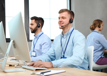 Photo of Technical support operator working with colleagues in office