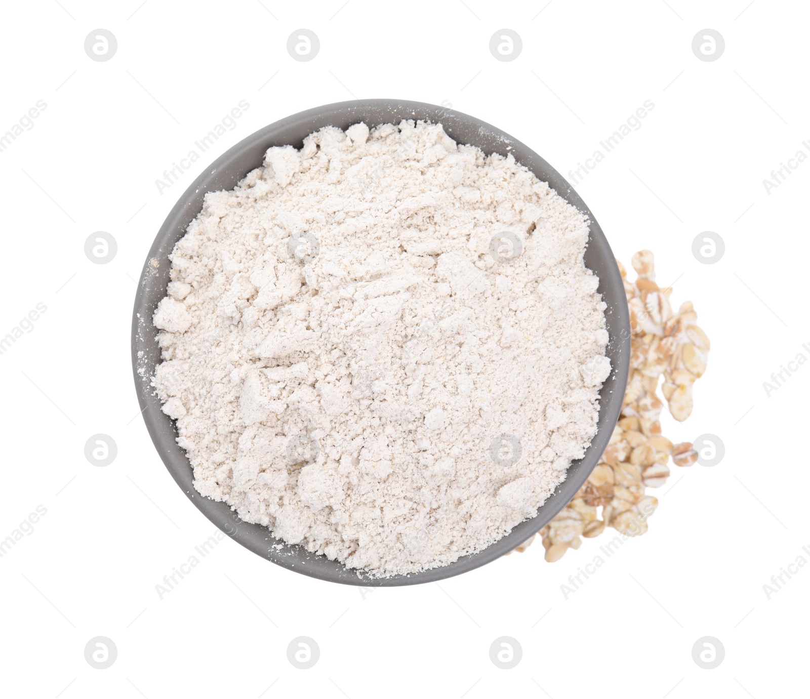 Photo of Bowl with oat flour and flakes on white background, top view