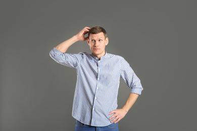 Emotional man in casual outfit on grey background