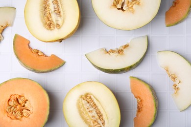 Tasty colorful ripe melons on white checkered table, flat lay