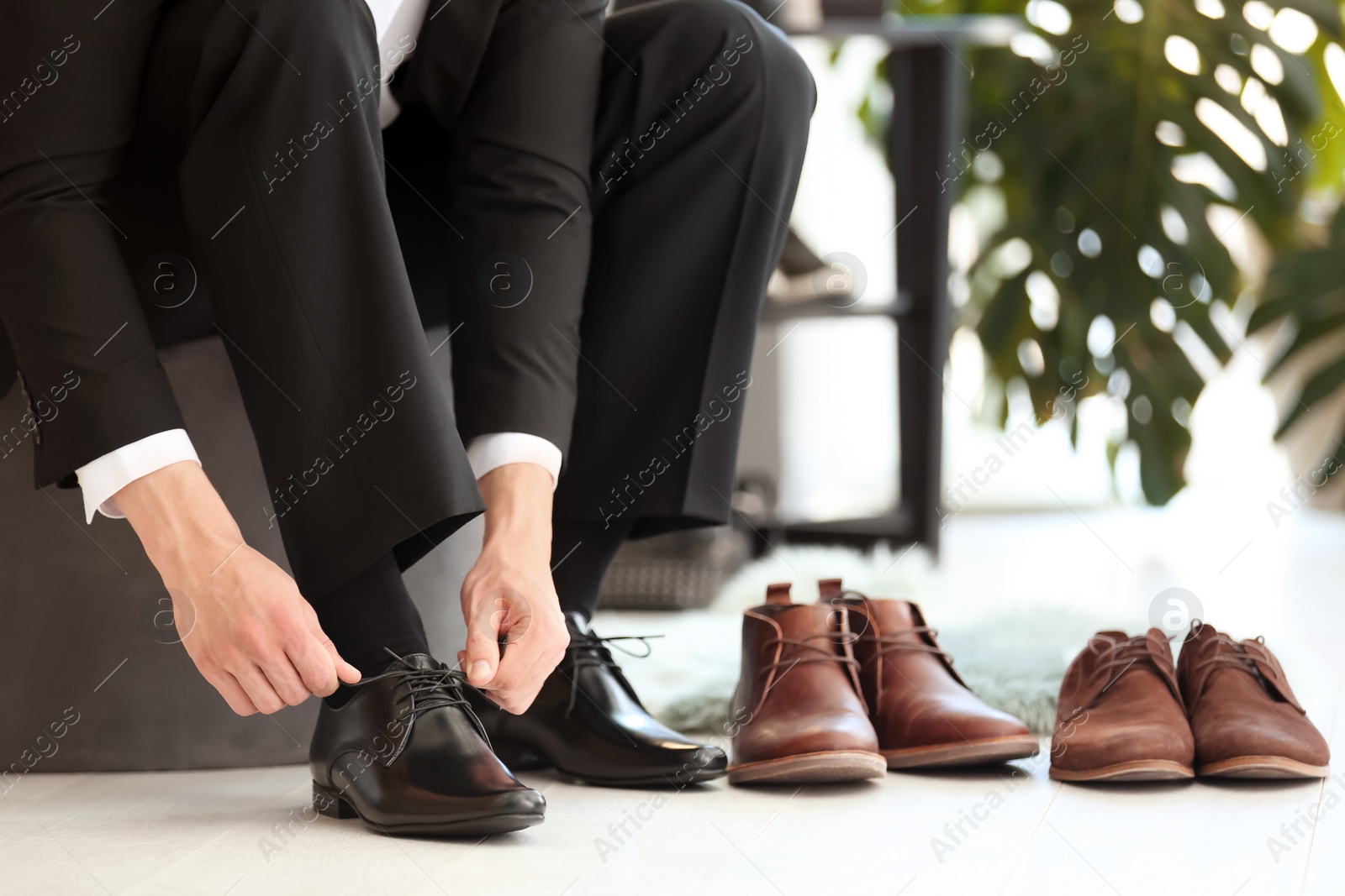 Photo of Young man trying on shoes in store