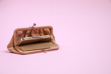 Open stylish beige leather purse on pink background, space for text