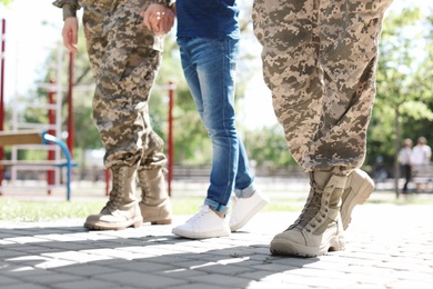 Military couple with their son walking in park
