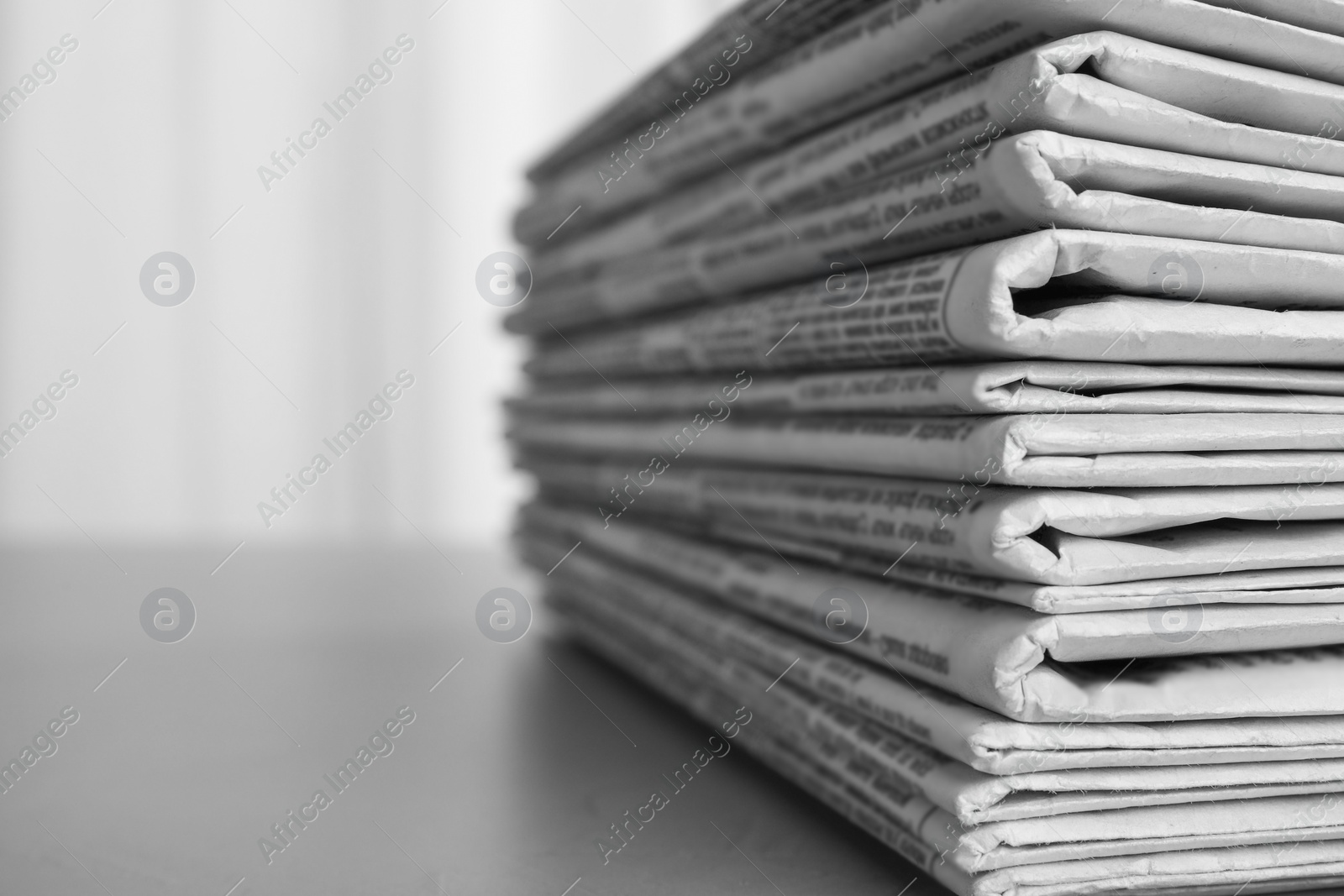 Photo of Stack of newspapers on grey table, space for text. Journalist's work