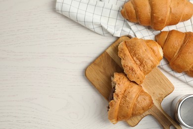 Photo of Tasty croissants with chocolate on white wooden table, flat lay. Space for text