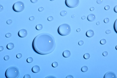 Water drops on color background, top view