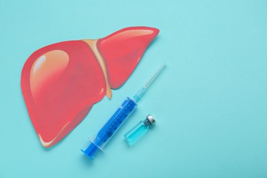 Photo of Paper liver, syringe and vial on turquoise background, flat lay with space for text. Hepatitis treatment