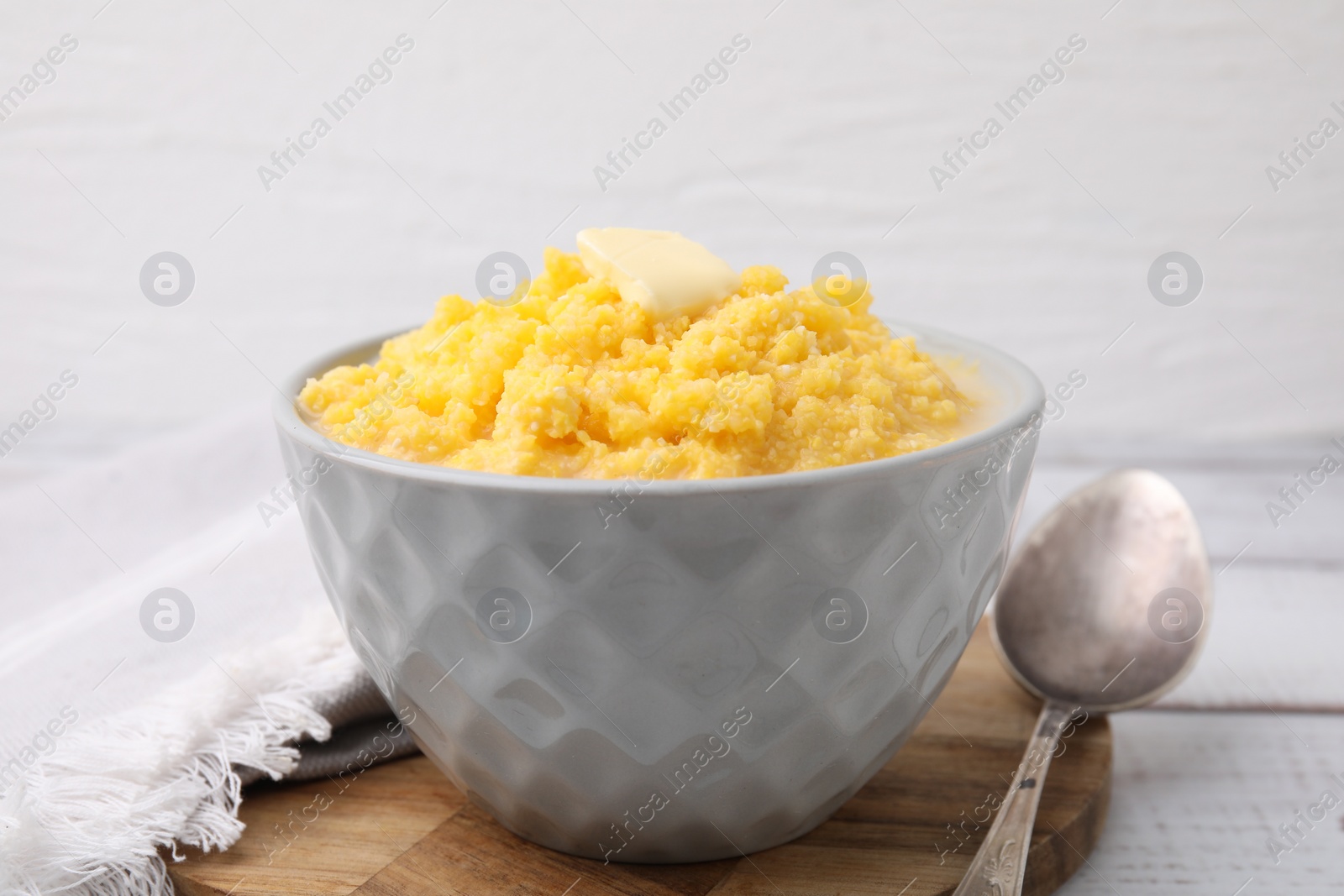 Photo of Tasty cornmeal with butter in bowl served on table, closeup