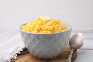 Photo of Tasty cornmeal with butter in bowl served on table, closeup