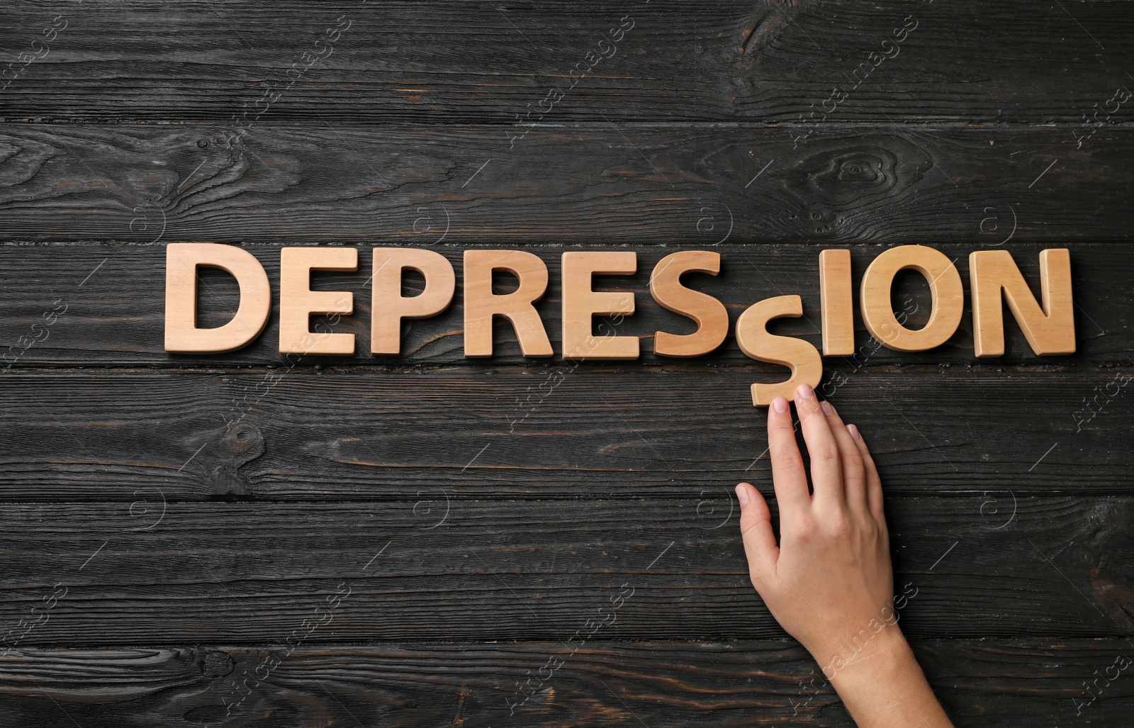 Photo of Woman making word Depression with letters on dark wooden background, top view