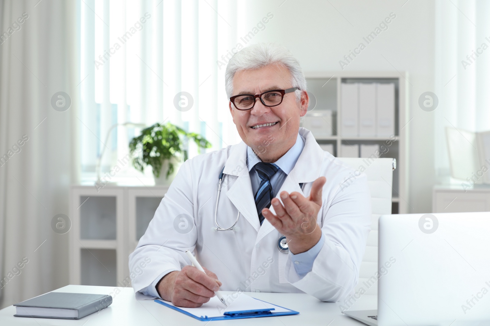 Photo of Portrait of senior doctor in white coat at workplace