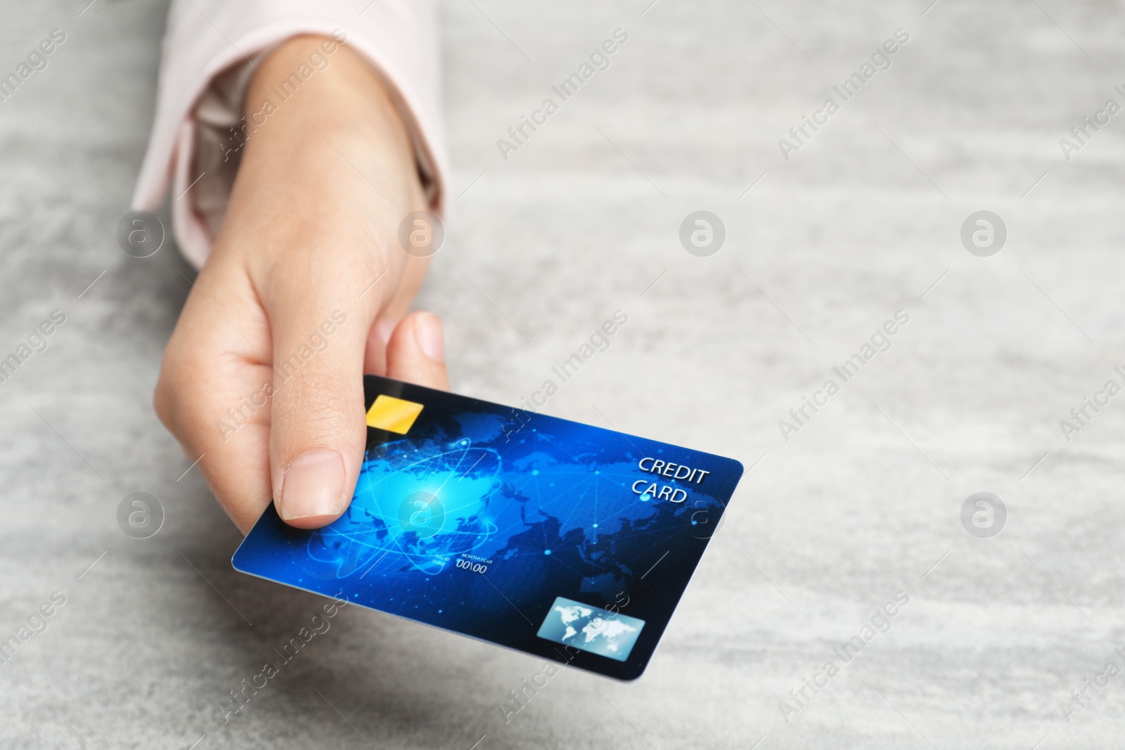 Photo of Young woman holding credit card over table