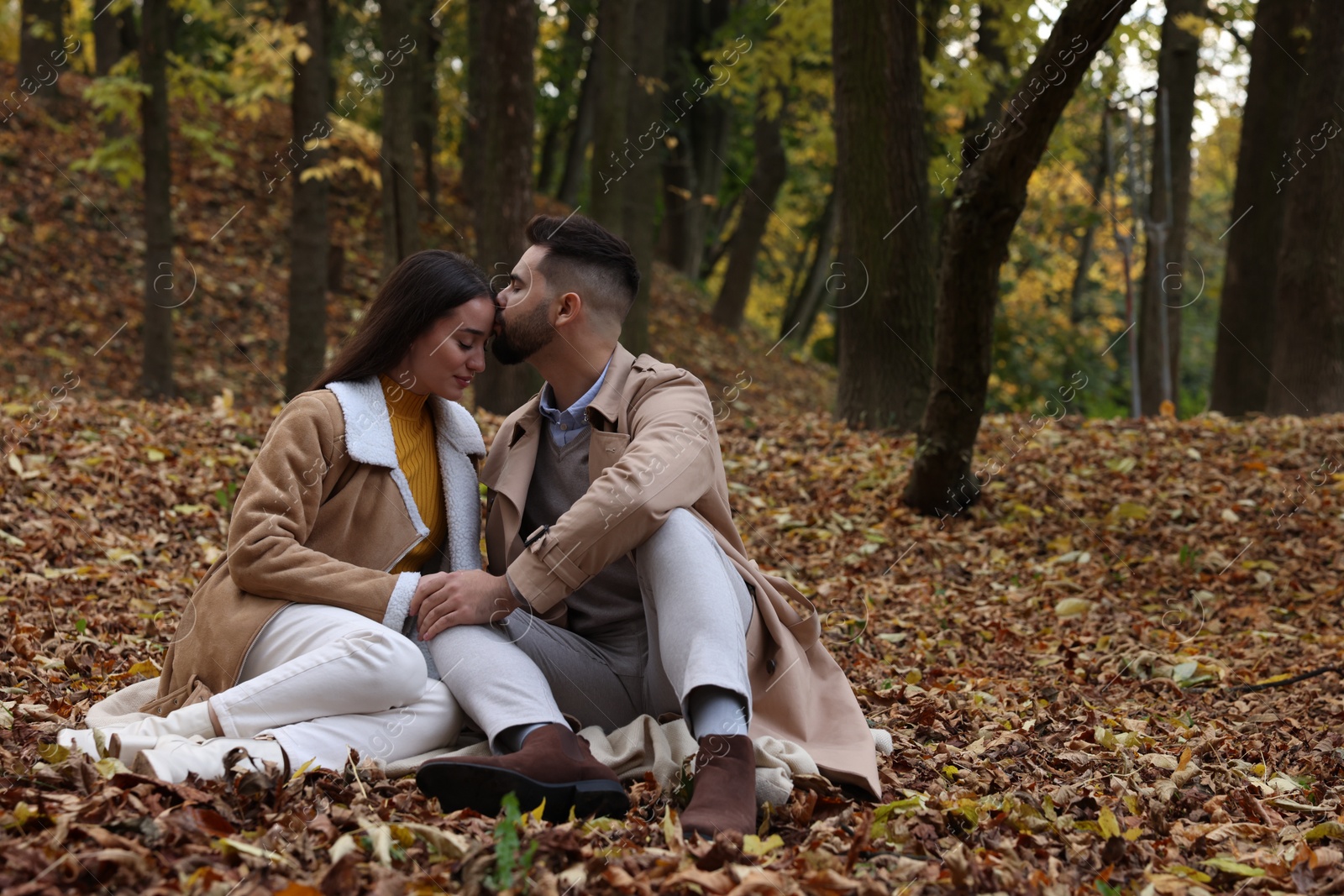 Photo of Romantic young couple spending time together in autumn park, space for text