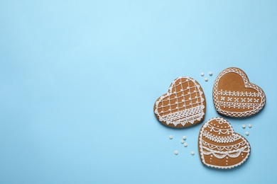 Photo of Tasty heart shaped gingerbread cookies on light blue background, flat lay. Space for text