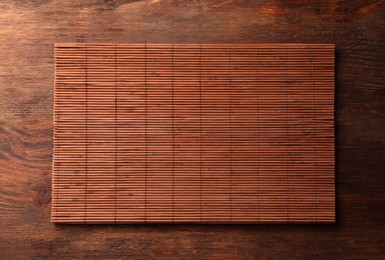 Bamboo mat on wooden table, top view. Space for text