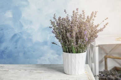 Pot with blooming lavender flowers on table