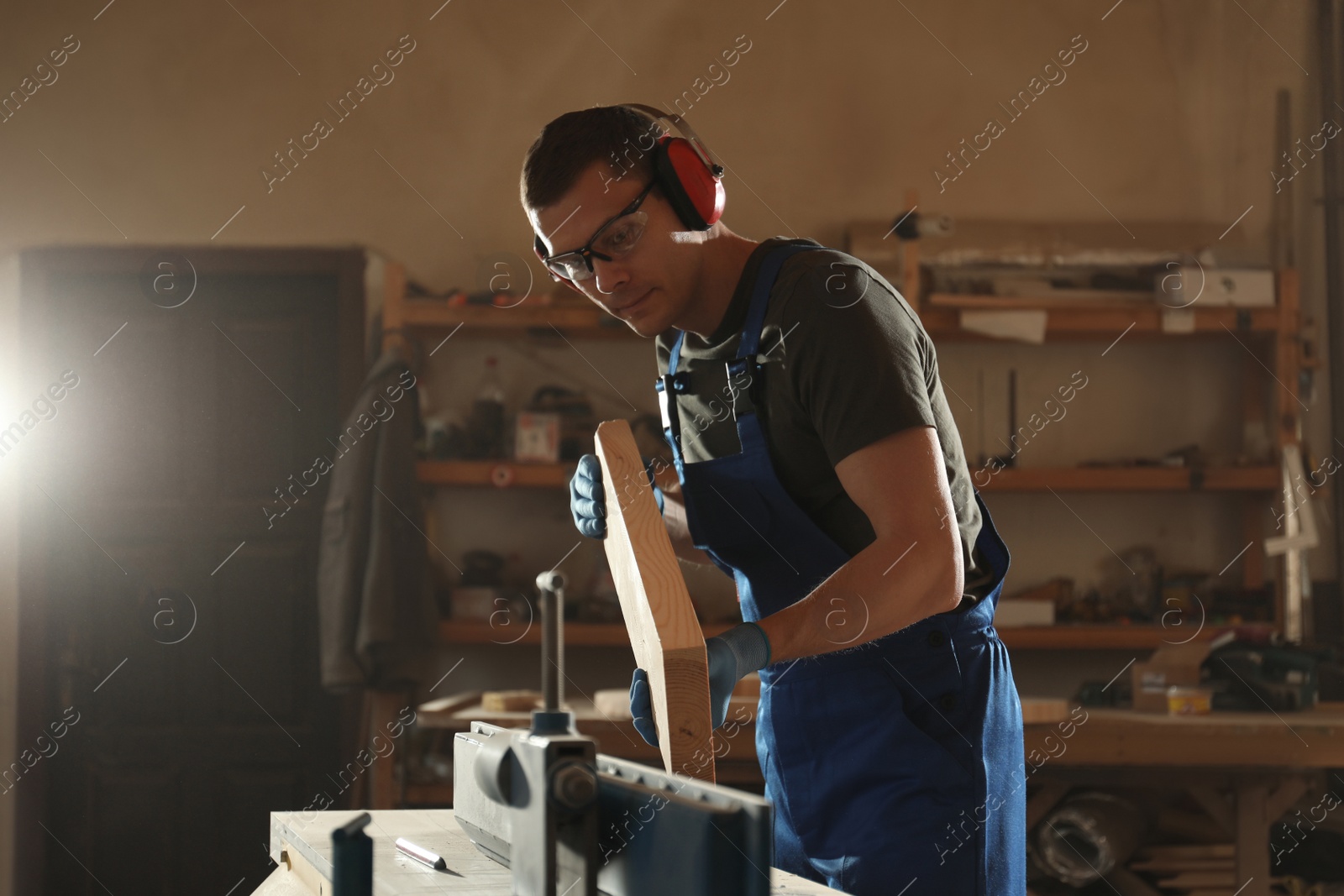 Photo of Professional carpenter working with wood in shop