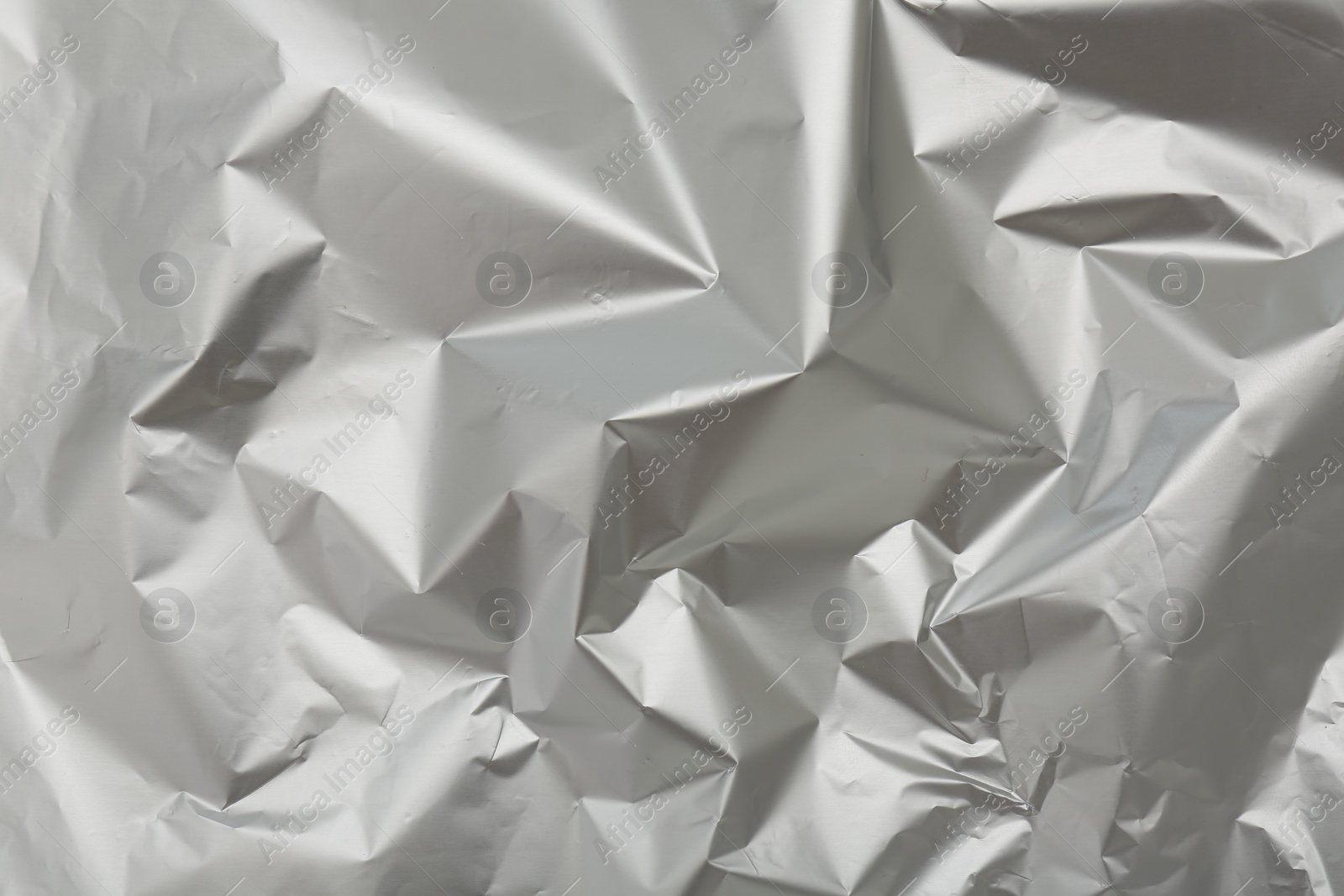 Photo of Crumpled silver foil as background, top view