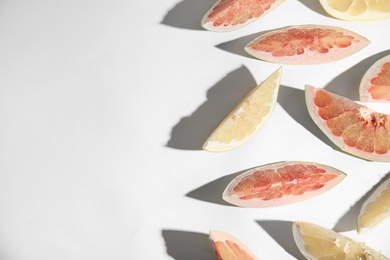 Photo of Slices of different ripe pomelos on white background, flat lay. Space for text