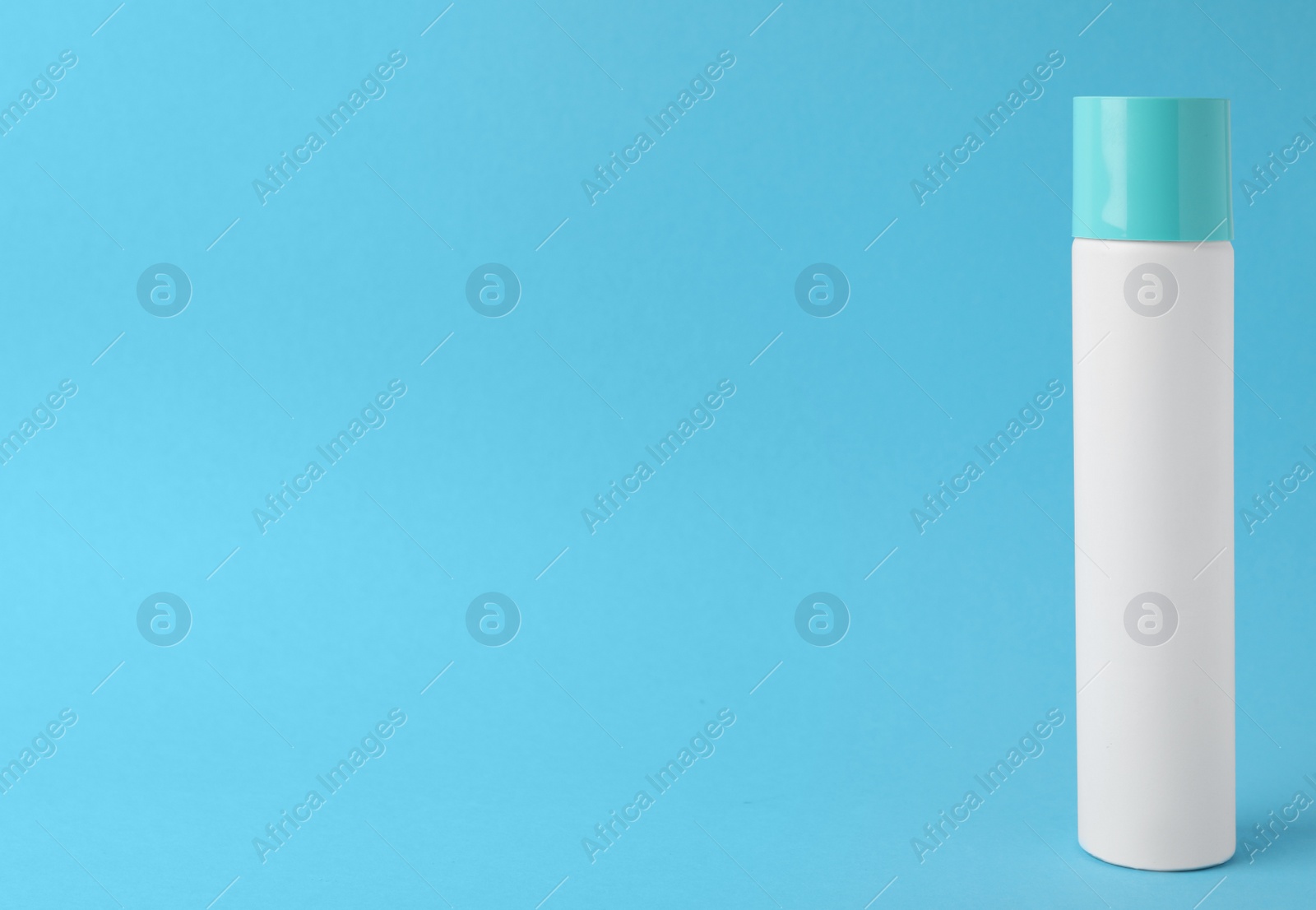 Photo of Bottle of dry shampoo on turquoise background. Space for text