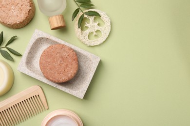 Photo of Flat lay composition of solid shampoo bars, loofah and comb on green background. Space for text