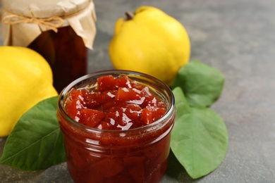 Delicious quince jam on grey table, closeup