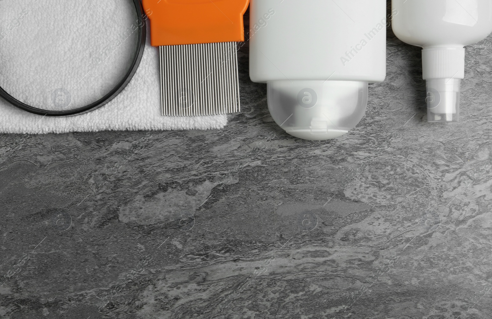 Photo of Cosmetic products, lice comb, magnifying glass and towel on grey table, flat lay. Space for text