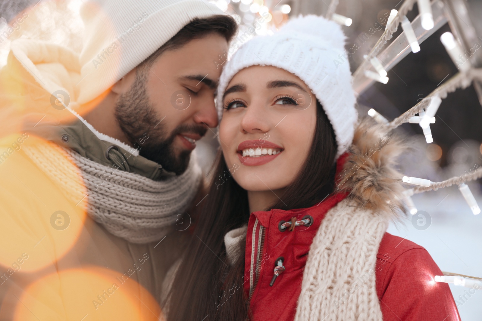 Photo of Happy young couple spending time together at winter fair. Christmas celebration