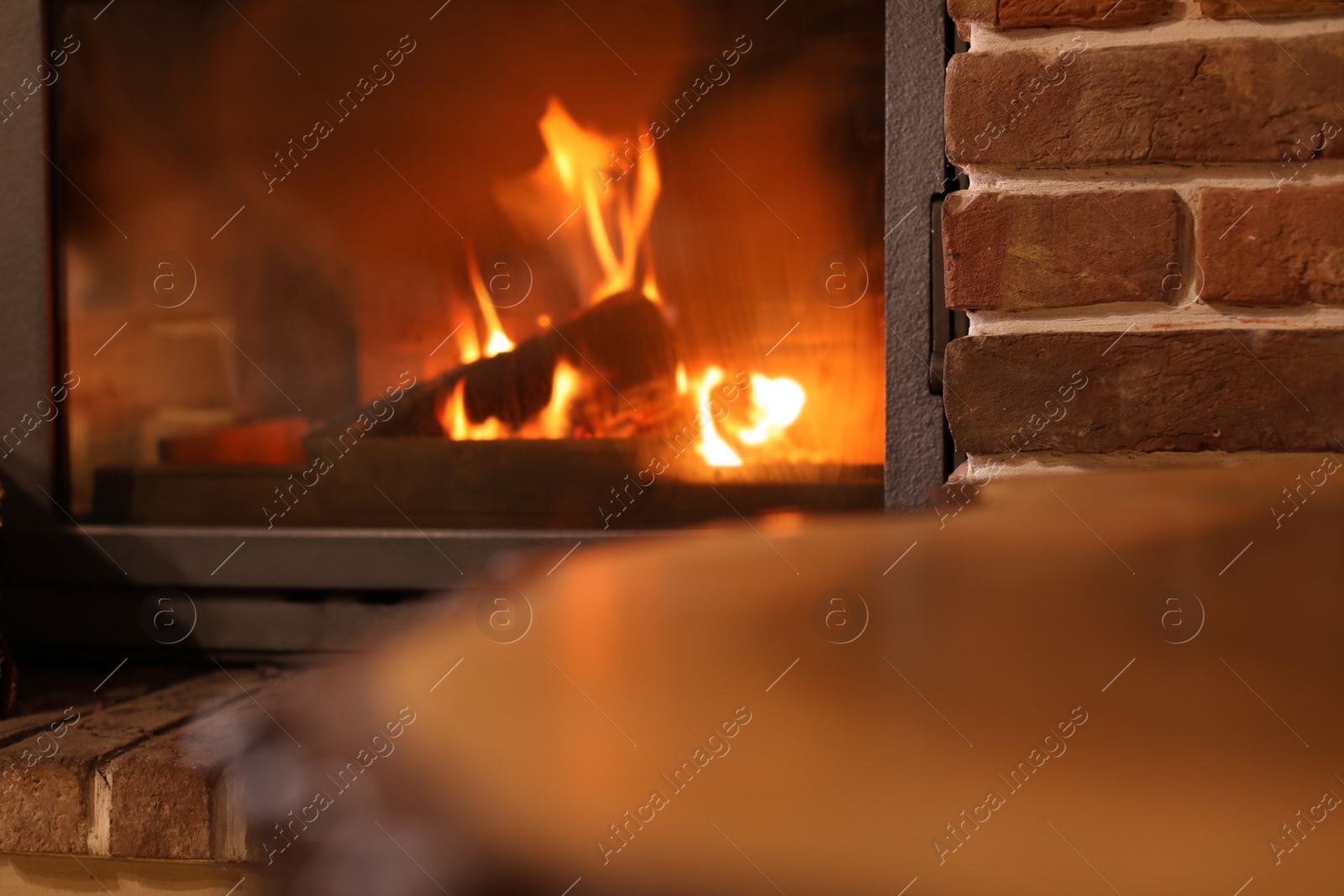 Photo of Fireplace with burning wood indoors. Winter vacation