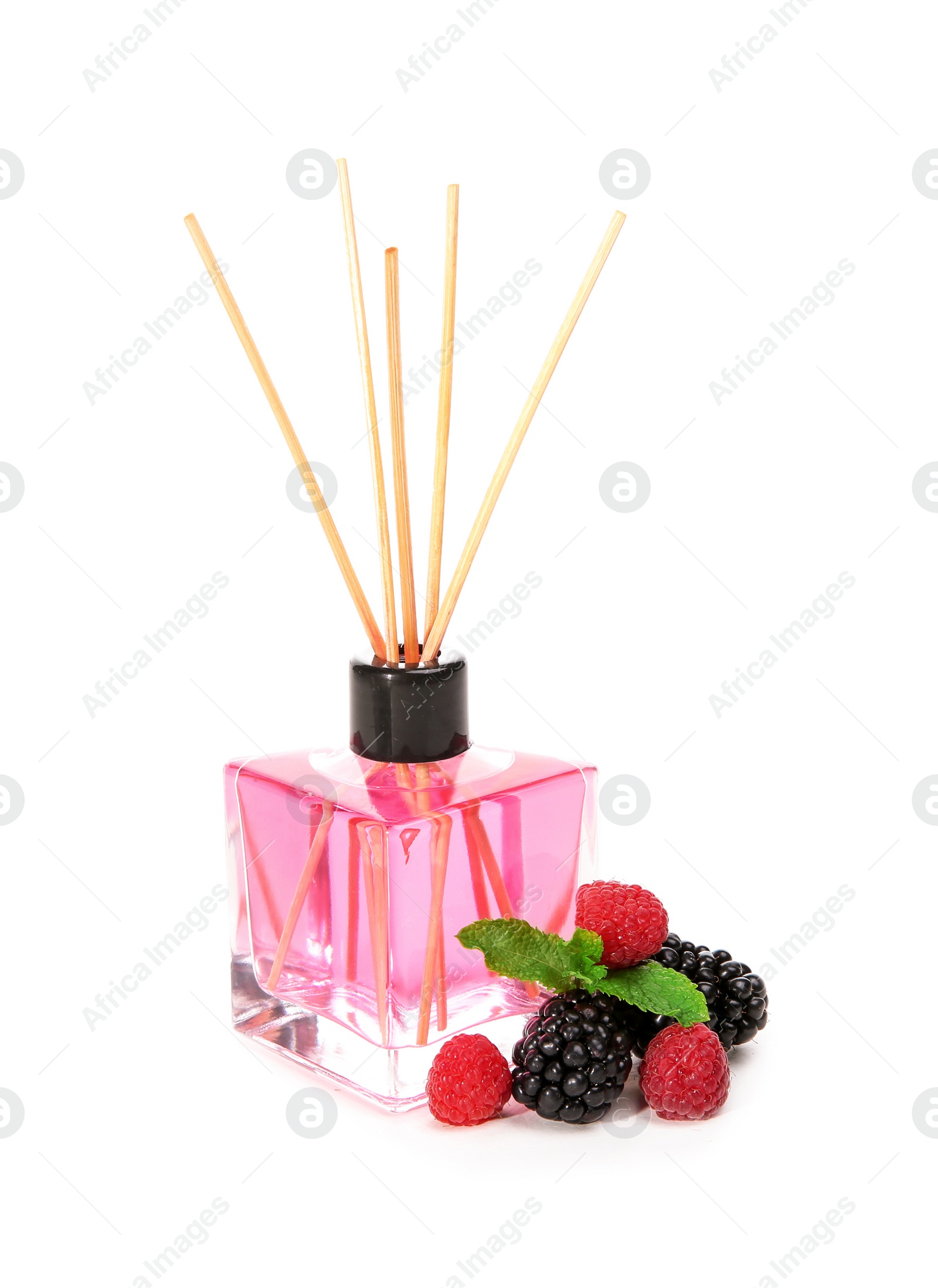 Photo of Aromatic reed air freshener and berries on white background