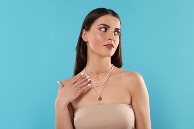 Photo of Beautiful woman with elegant jewelry on light blue background