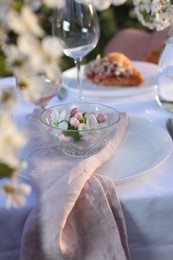 Stylish table setting with beautiful spring flowers in garden