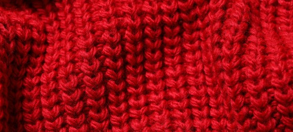 Photo of Texture of soft red knitted fabric as background, closeup