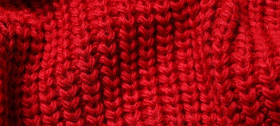 Texture of soft red knitted fabric as background, closeup