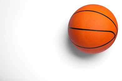 Photo of Orange ball on white background, top view. Basketball equipment
