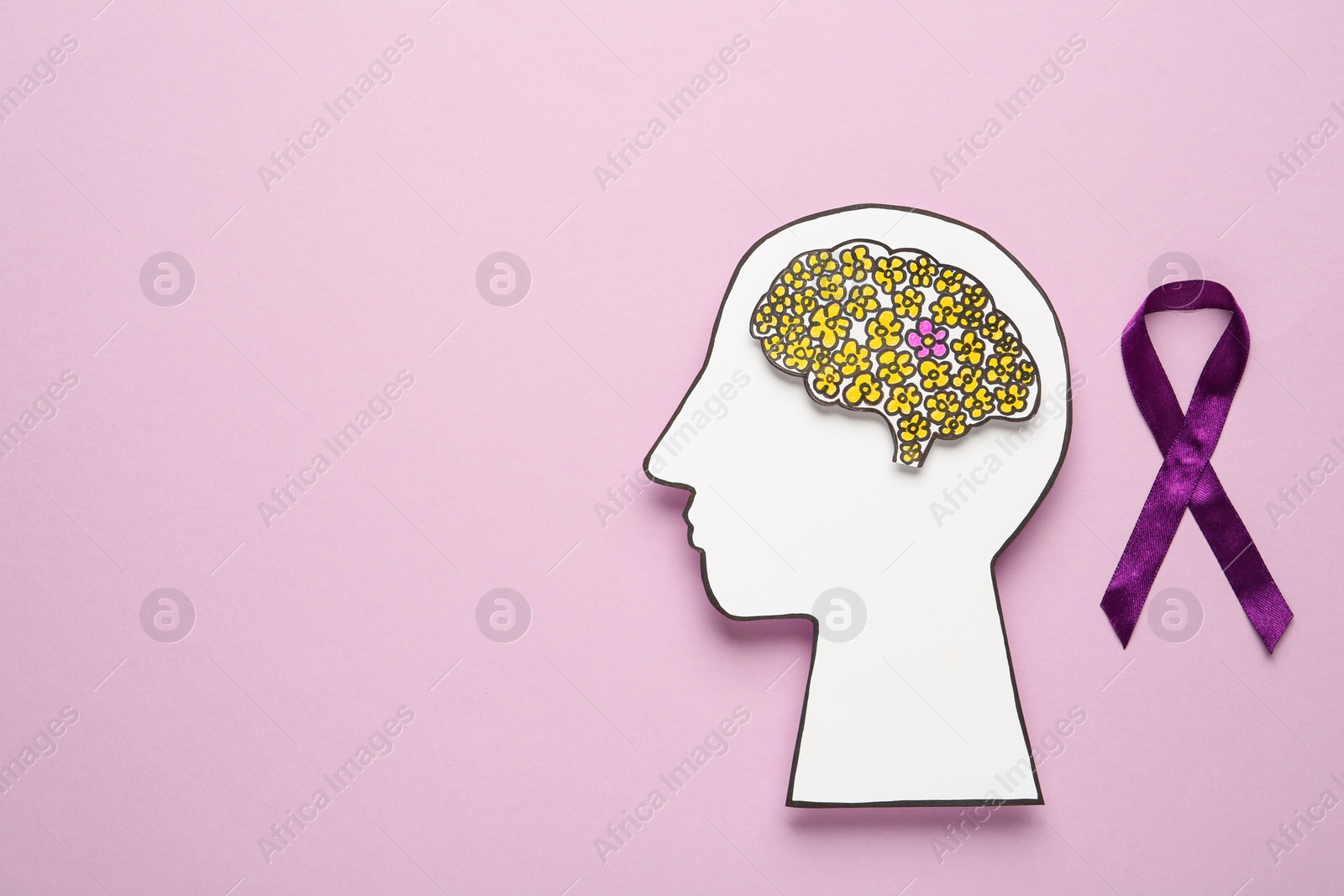 Photo of Human head cutout with brain near purple ribbon on pink background, flat lay. Epilepsy awareness