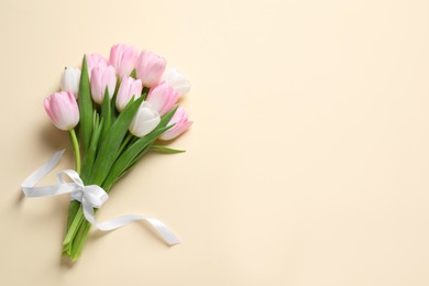 Beautiful pink spring tulips on beige background, top view. Space for text