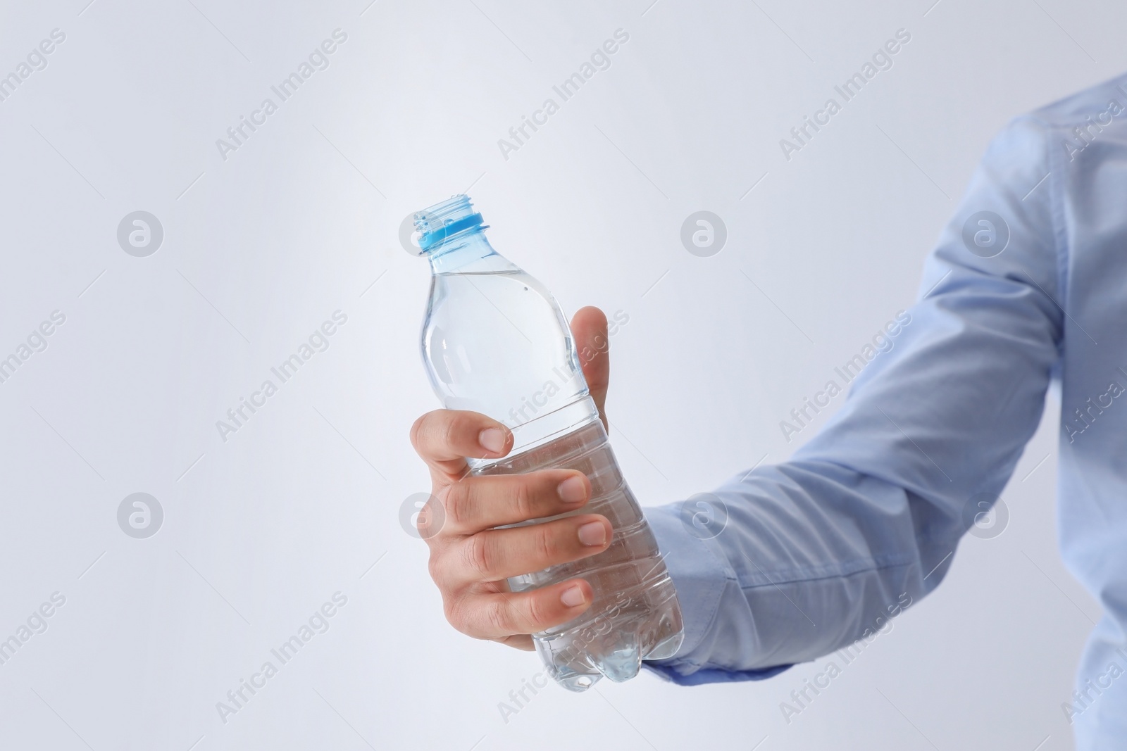 Photo of Man holding bottle of pure water on white background, closeup