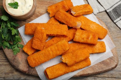 Photo of Tasty fresh fish fingers served on wooden table, flat lay