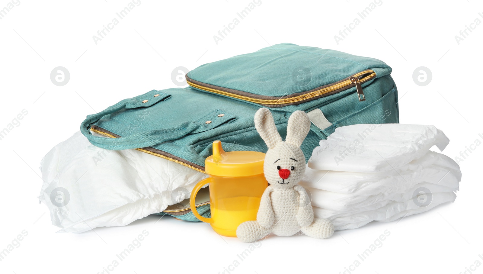 Photo of Backpack with disposable diapers and child's accessories on white background